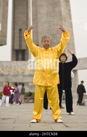 Uomo in Tai Chi vestire fare mattina Tai Chi al Bund su Zhongshan Road, Cina, Shanghai Foto Stock