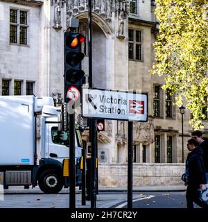 Victoria Westminster London Inghilterra UK, 7 novembre 2021, Young Couple Crossing Road con un Truch bianco e un semaforo rosso Foto Stock