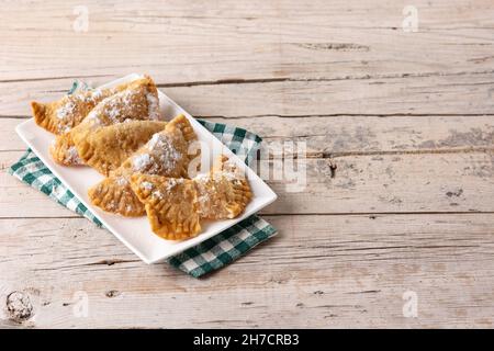 Pasticceria spagnola ripiena di capelli d'angelo su tavola di legno Foto Stock