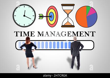 Concetto di gestione del tempo disegnato su un muro guardato dal business persone Foto Stock
