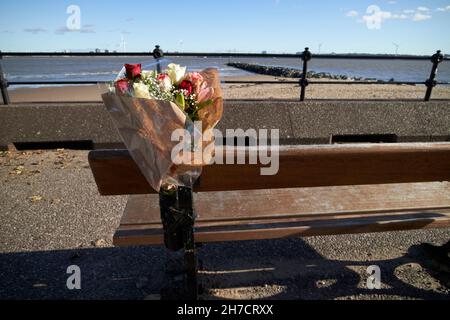 Bouquet floreale tributo lasciato sul banco del parco dedicato alla persona anziana che ha amato la vista da questa panchina New Brighton il Wirral merseyside uk Foto Stock