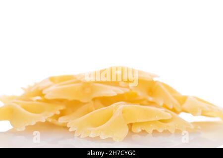 Pasta cruda giallo chiaro, a forma di farfalla, primo piano, isolata su bianco. Foto Stock