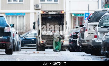 Camion dei rifiuti, carretto con elevatore del bidone, rimozione dei rifiuti domestici nella zona residenziale in inverno, Mosca, 22 novembre 2021 Foto Stock