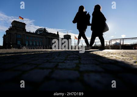 Berlino, Germania. 22 novembre 2021. La silhouette di due persone è visibile di fronte al Reichstag di Berlino, 22 novembre 2021. Copyright: Florian Gaertner/photothek.de Credit: dpa/Alamy Live News Foto Stock