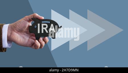 Mano detiene Piggy banca con IRA conto previdenza individuale. Foto Stock