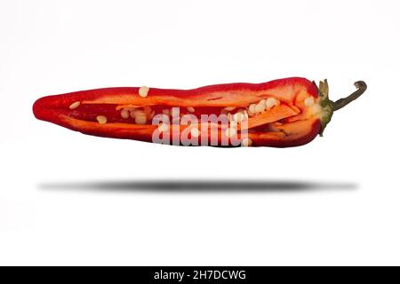 Peperoncino rosso caldo tagliato a fette a metà da vicino isolato su sfondo bianco con ombra Foto Stock