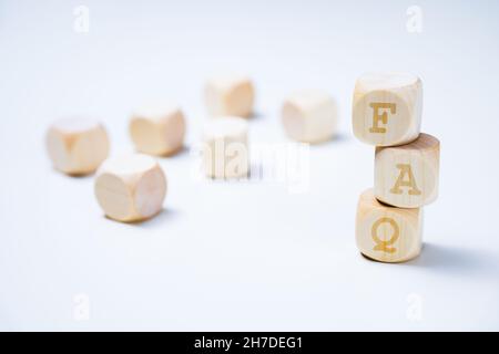 Informazioni sulle domande frequenti. Dadi in legno con le lettere FAQ su sfondo bianco. Foto Stock