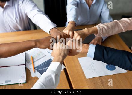 Unità del team aziendale. Gruppo di colleghi multietnici che si uniscono a Fists in Office Foto Stock