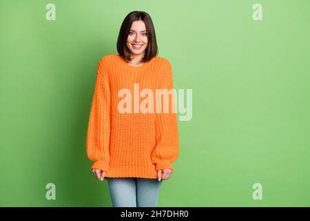 Ritratto di attraente ragazza divertente allegra indossare abiti morbidi oversize posa isolato su sfondo verde brillante Foto Stock