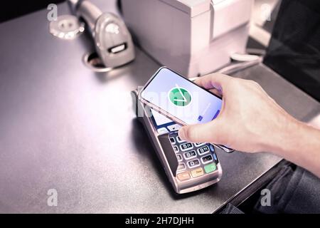 Pagamento tramite telefono. A pagamento con la tecnologia mobile nfc Contactless. Portafoglio elettronico e app per carte di credito bancarie sullo smartphone. Acquisto facile e sicuro. Foto Stock