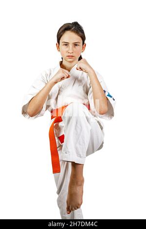 Karate ragazza su sfondo bianco. Una bruna atletica caucasica in un kimono bianco è impegnato in arti marziali e di pratica calci. Sport di contatto. H Foto Stock