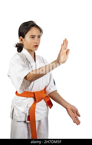 Karate ragazza su sfondo bianco. Una bruna atletica caucasica in un kimono bianco pratica le arti marziali. Stile di vita sano Foto Stock