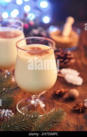 Buon Natale. Delizioso cocktail invernale latte, rum e cannella serviti in due bicchieri con biscotti di zucchero a forma di stella shortbread, ramo di abete su Whi Foto Stock