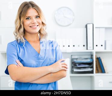 Ragazza medico sorge nei pressi di un tavolo in ufficio Foto Stock