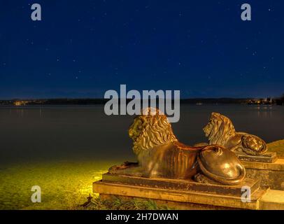 Leoni bavaresi di fronte al Midgardhaus di notte, Tutzing, Lago Starnberg, alta Baviera, Baviera, Germania Foto Stock