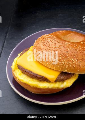 Un bagel di semi di sesamo con salsiccia, uova e formaggio per colazione (USA) Foto Stock