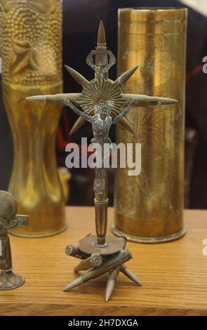 Crocifisso fatto di cartucce di fucili raccolte sul campo di battaglia durante la prima guerra mondiale in mostra nel Museo Armistizio nella Foresta di Compiègne (Forêt de Compiègne) vicino a Compiègne in Francia. I soldati anteriori passarono la maggior parte del loro tempo ad aspettare, molti di loro si tenevano impegnati a creare oggetti cosiddetti trench-handcraft. Questi erano un'ampia varietà di oggetti fatti dalle macerie raccolte sul campo di battaglia. Il Museo dell'Armistizio si trova sul terreno della Glade dell'Armistizio dove fu firmato l'Armistizio del 11 novembre 1918 che concluse la prima guerra mondiale. Foto Stock