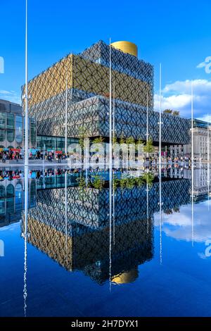 La Biblioteca di Birmingham dagli architetti Mecanno. Completata nel 2013, la più grande biblioteca del Regno Unito. Un lago poco profondo all'esterno crea meravigliosi riflessi. Foto Stock