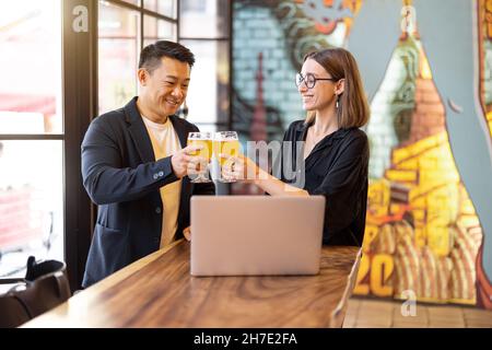 Gli amici parlano e bevono birra al bar Foto Stock