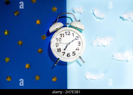 Ritmi circadiani con sveglia bianca, sfondi notte e giorno spazio copia flatlay Foto Stock