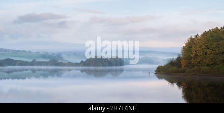 Pescatore in piedi in acqua a Fewston Reservoir, North Yorkshire Foto Stock