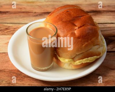 Indiano Masala Chai con pane Bun Maska su piatto bianco, fuoco selettivo Foto Stock