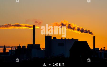 Berlino, Germania. 22 novembre 2021. Nuvole di fumo sorgono da un camino. Il sole che tramonta fa illuminare le nuvole e il fumo arancione. Credit: Philipp Znidar/dpa/Alamy Live News Foto Stock