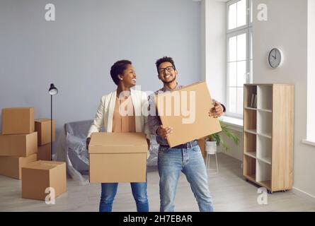 Ritratto di allegra giovane coppia afroamericana innamorata che si sposta in una nuova casa. Foto Stock