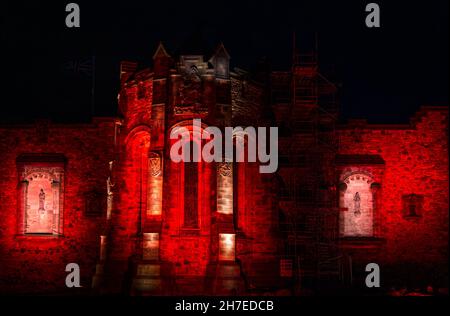 La parte superiore del Castello di Edimburgo si illuminò di rosso di notte, Scozia, Regno Unito Foto Stock