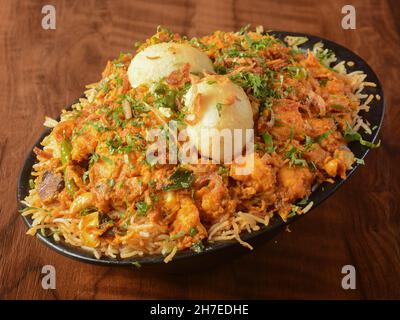 Biryani tradizionale pollo Mughal fatto di riso Basmati cotto con spezie masala e uova sode, fuoco selettivo Foto Stock
