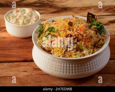 hyderabadi tradizionale vegetale / Veg dum biryani con verdure miste servite con raita mista, fuoco selettivo Foto Stock