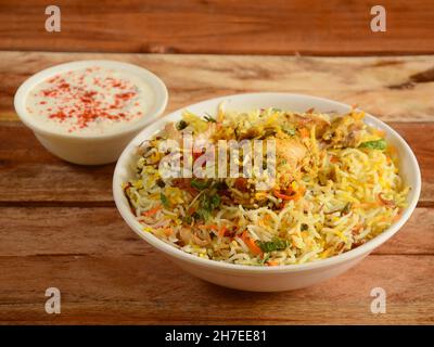 Tradizionale Hiderabadi Chicken dum Biryani a base di riso Basmati cotto con spezie masala, servito con yogurt, fuoco selettivo Foto Stock