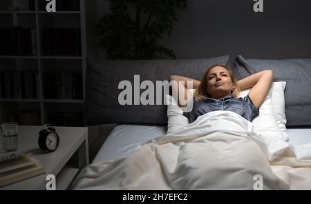 Donna rilassante nel letto Foto Stock