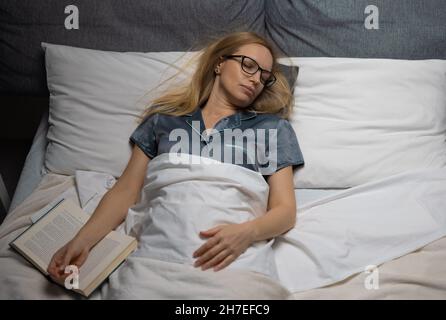 Donna che Dorme con libro Foto Stock