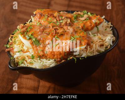 Tradizionale Biryani uovo - riso Basmati cotto con masala e spezie e condito con uova sode a fette e curry ananda, fuoco selettivo Foto Stock