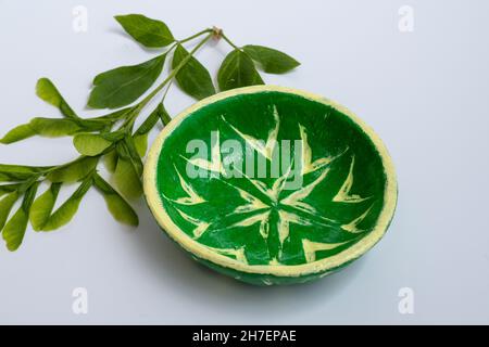 Ciotola di ceramica con stampe applicate di semi di pianta, mentre l'argilla è morbida. Fatto a mano, applicato e dipinto a mano. Foto Stock