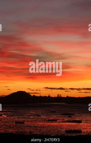 Silhouette dello skyline della passeggiata di Morecambe al tramonto con cielo colorfulpink e colori riflessi in riva al mare a Morecambe, Lancashire, la sera di novembre. Foto Stock