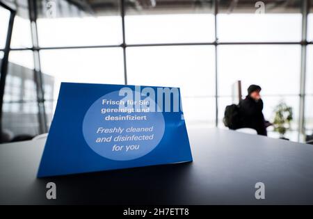 Amburgo, Germania. 18 Nov 2021. Un cartello con il testo "appena pulito e disinfettato per te" si trova su un tavolo chiuso a chiave nella lounge dell'aeroporto del terminal 1 dell'aeroporto di Amburgo. A seguito di ingenti perdite di milioni di persone dovute alla pandemia di Corona, anche il traffico aereo quest'anno sta subendo un leggero aumento ad Amburgo. Rispetto all'anno pandemico 2020, un maggior numero di aerei decolterà di nuovo da Amburgo nel prossimo inverno, ma il numero di passeggeri è ancora lontano dal livello prima della pandemia di Corona. Credit: Christian Charisius/dpa/Alamy Live News Foto Stock