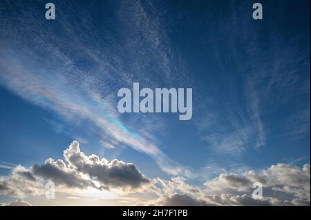 Cirrocumulo nuvole ondulate con colori spettrali iridescenti per riflessione o rifrazione, un fenomeno ottico contro un cielo profondo, spazio di copia, selec Foto Stock