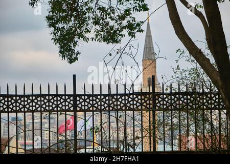 Minareto di una moschea vista dal parco Gulhane istanbul con Antico sfondo della Torre Galata durante il giorno di pioggia e di coperto istanbul nel mese di marzo Foto Stock