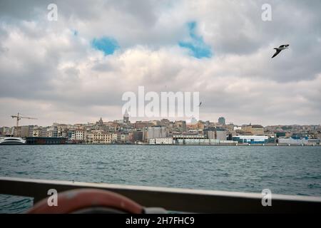 Il corno d'oro della torre Galata di istanbul scattando foto dal traghetto pedonale per il trasporto interno a istanbul durante il tempo sovrastato e il gabbiano Foto Stock