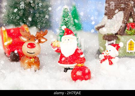 biglietto di auguri di natale, babbo natale, uomo di neve e renne con regali in slitta, concetto Foto Stock