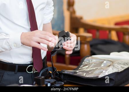 gerusalemme-israele. 24-01-2020. Una chiusura - su di un ragazzo di bar mitzvah ebraico, indossando una camicia bianca e una cravatta rossa. Indossando un tefillin per la prima volta in Foto Stock