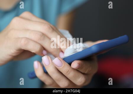 Donna pulizia cellulare schermo con salvietta bagnata da batteri Foto Stock