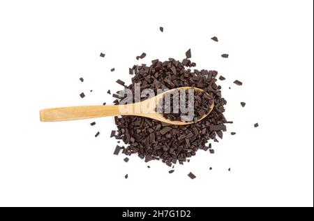 Il cioccolato viene cosparso in un cucchiaio di legno isolato su sfondo bianco. Cioccolato grattugiato isolato su sfondo bianco. Foto Stock