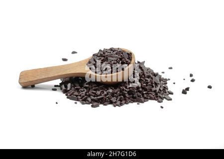 Il cioccolato viene cosparso in un cucchiaio di legno isolato su sfondo bianco. Cioccolato grattugiato isolato su sfondo bianco. Foto Stock