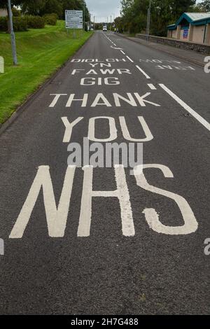 Un cartello che dice grazie NHS dipinto su una strada in Anglesey, Galles. Foto Stock
