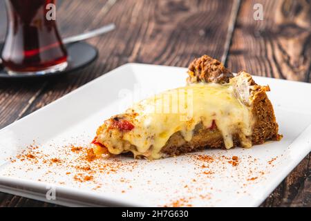 Torta quiche di funghi con tè su piatto bianco su tavola di legno Foto Stock