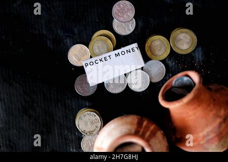 Primo piano di monete e brocche di argilla con un piccolo pezzo di carta con un messaggio. Foto Stock