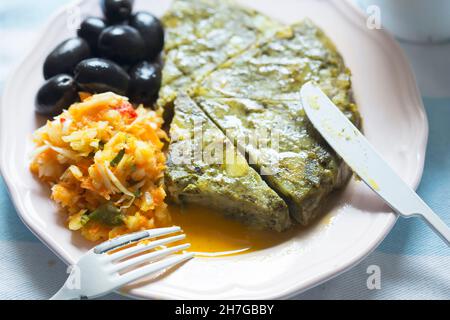 Tortilla di patate con spinaci con insalata di verdure e olive nere Foto Stock